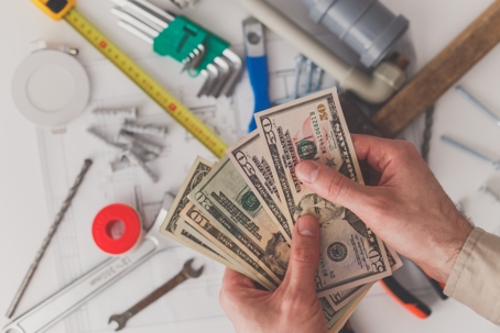 hands with money over pipes